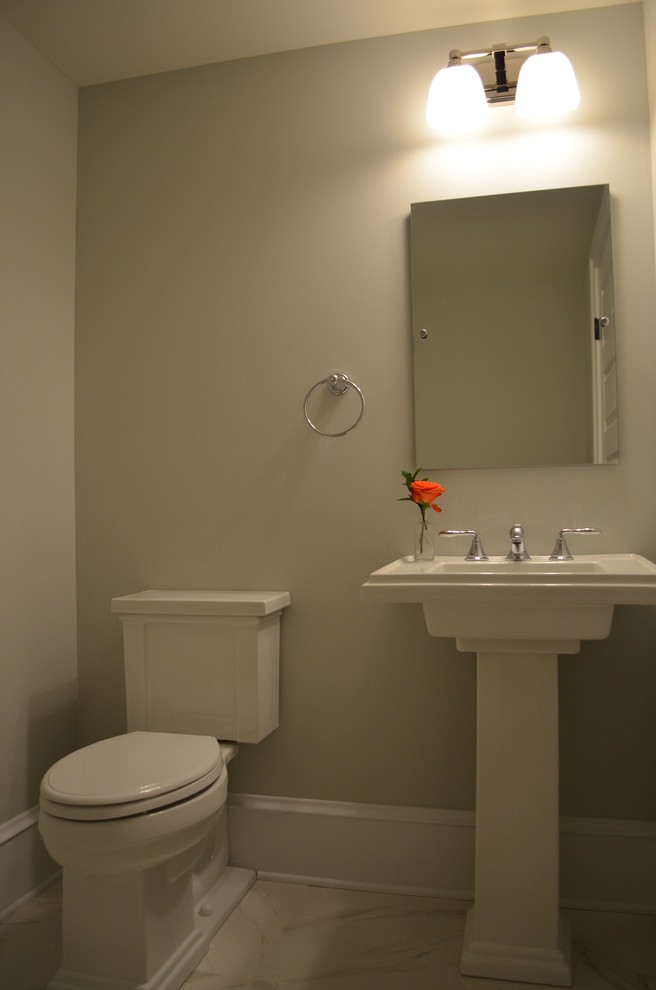 Mid-sized elegant porcelain tile powder room photo in Wilmington with a pedestal sink, a two-piece toilet and gray walls