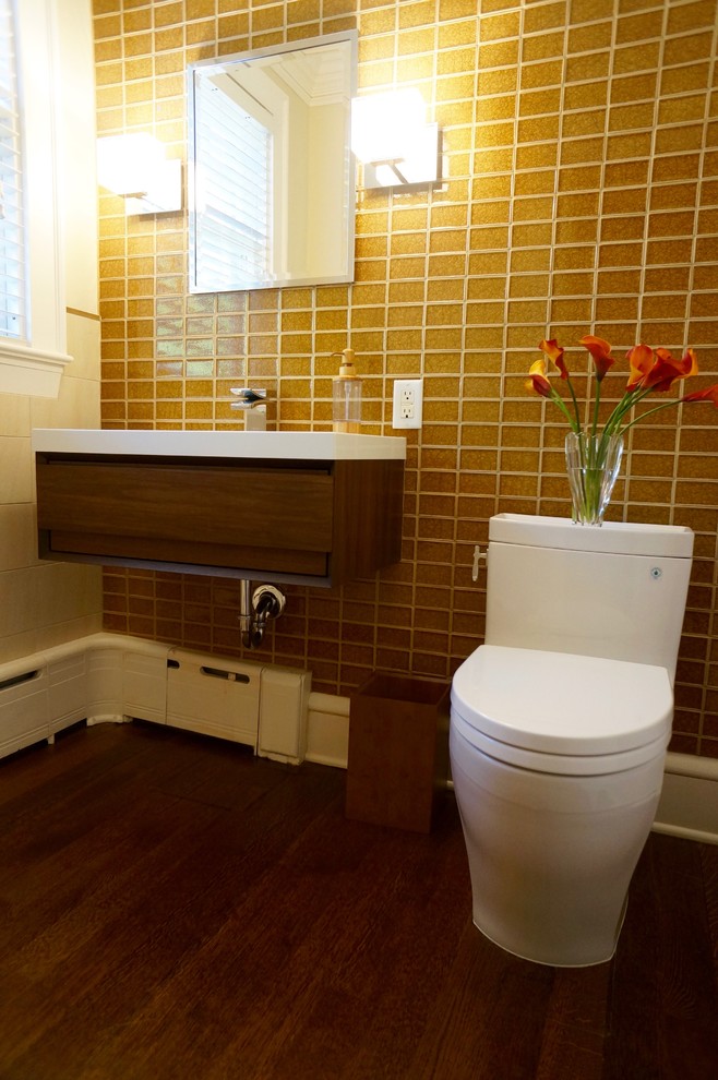 Medium sized contemporary cloakroom in Minneapolis with freestanding cabinets, dark wood cabinets, a one-piece toilet, multi-coloured tiles, glass tiles, beige walls, dark hardwood flooring, an integrated sink and engineered stone worktops.