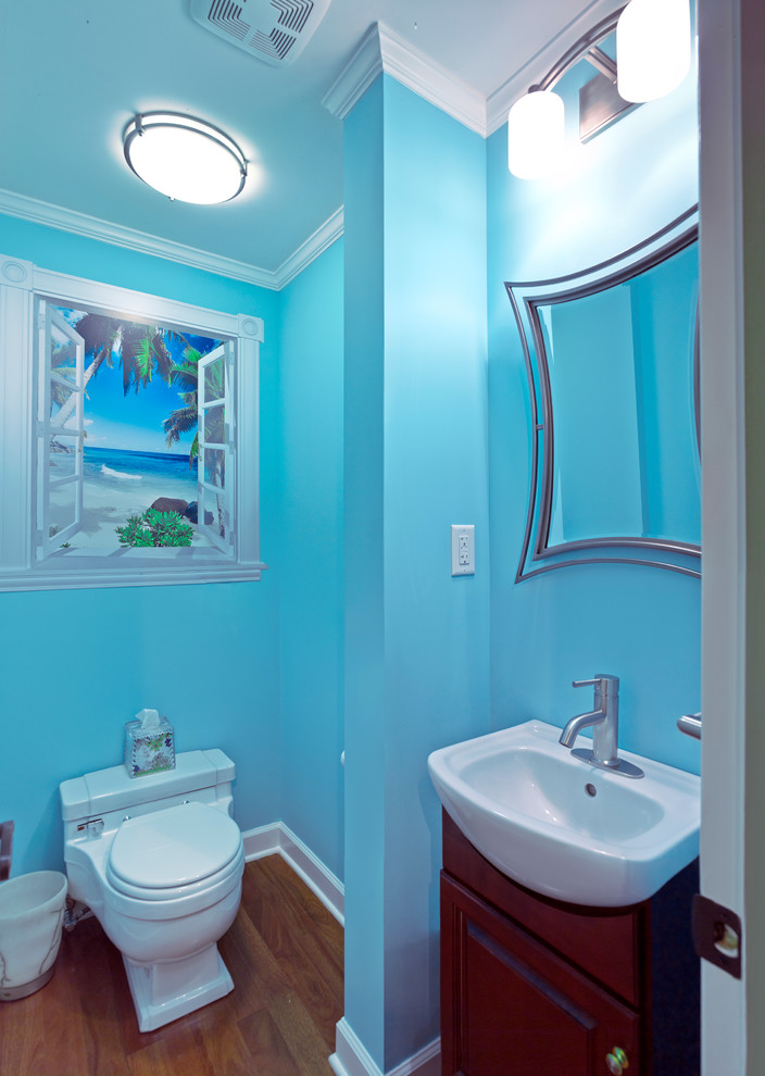 Пример оригинального дизайна: маленький туалет в морском стиле с раковиной с пьедесталом, унитазом-моноблоком, синими стенами и паркетным полом среднего тона для на участке и в саду