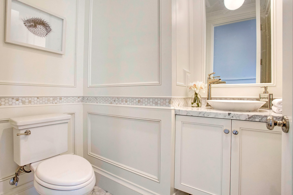 This is an example of a small traditional cloakroom in Los Angeles with recessed-panel cabinets, white cabinets, a two-piece toilet, multi-coloured tiles, marble tiles, white walls, marble flooring, a vessel sink, marble worktops, white floors and grey worktops.
