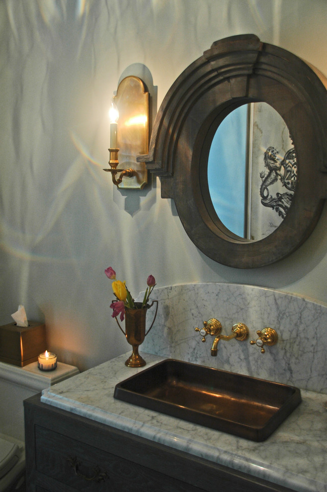 Foto på ett mellanstort lantligt toalett, med möbel-liknande, skåp i slitet trä, en toalettstol med separat cisternkåpa, grå kakel, porslinskakel, grå väggar, klinkergolv i porslin, ett nedsänkt handfat och granitbänkskiva