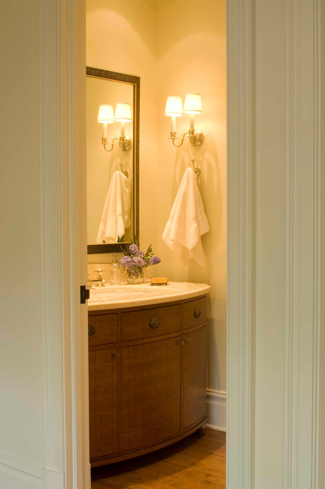 Idee per un piccolo bagno di servizio tradizionale con ante lisce, ante in legno scuro, top in marmo, pareti beige, pavimento in legno massello medio e lavabo sottopiano