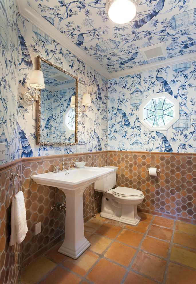 На фото: туалет в средиземноморском стиле с разноцветными стенами, полом из терракотовой плитки и раковиной с пьедесталом