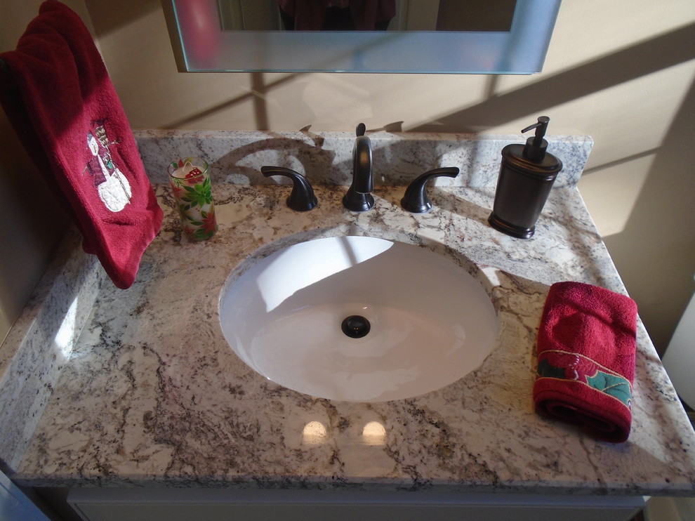 Foto di un piccolo bagno di servizio chic con ante bianche, lavabo sottopiano e top in granito