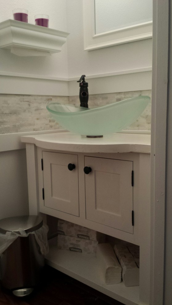 Immagine di un piccolo bagno di servizio tradizionale con lavabo a bacinella, ante lisce, ante bianche, top in legno, WC a due pezzi e piastrelle grigie