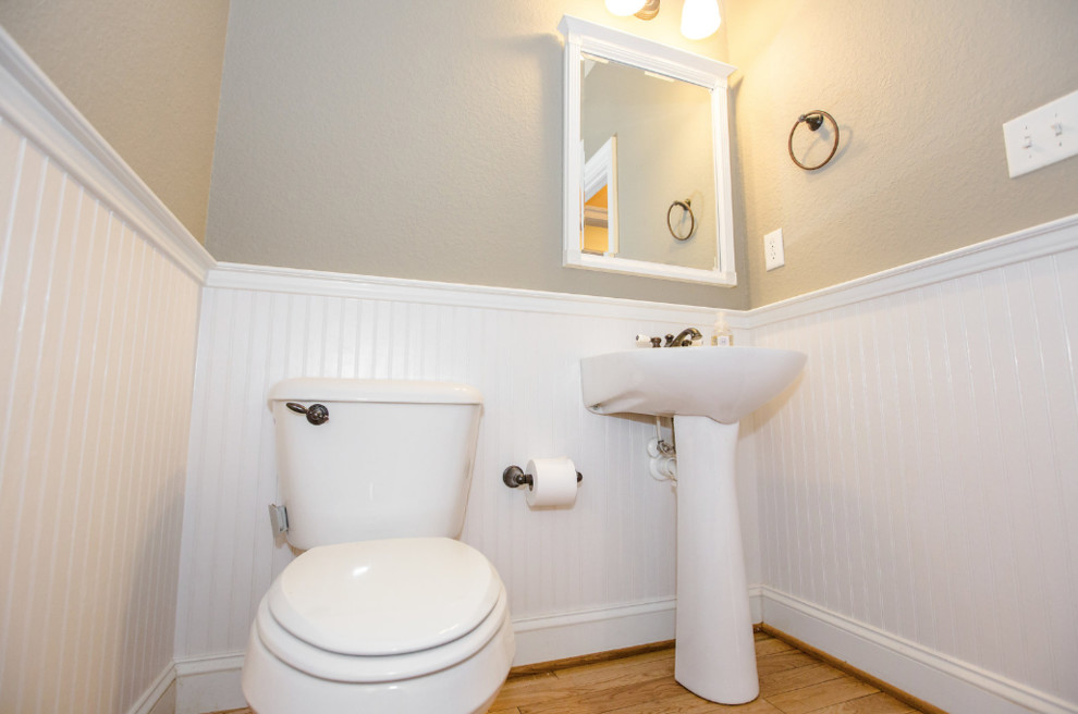 Ispirazione per un bagno di servizio stile marino con WC a due pezzi, pareti beige, parquet chiaro, lavabo a colonna, pavimento marrone e top bianco