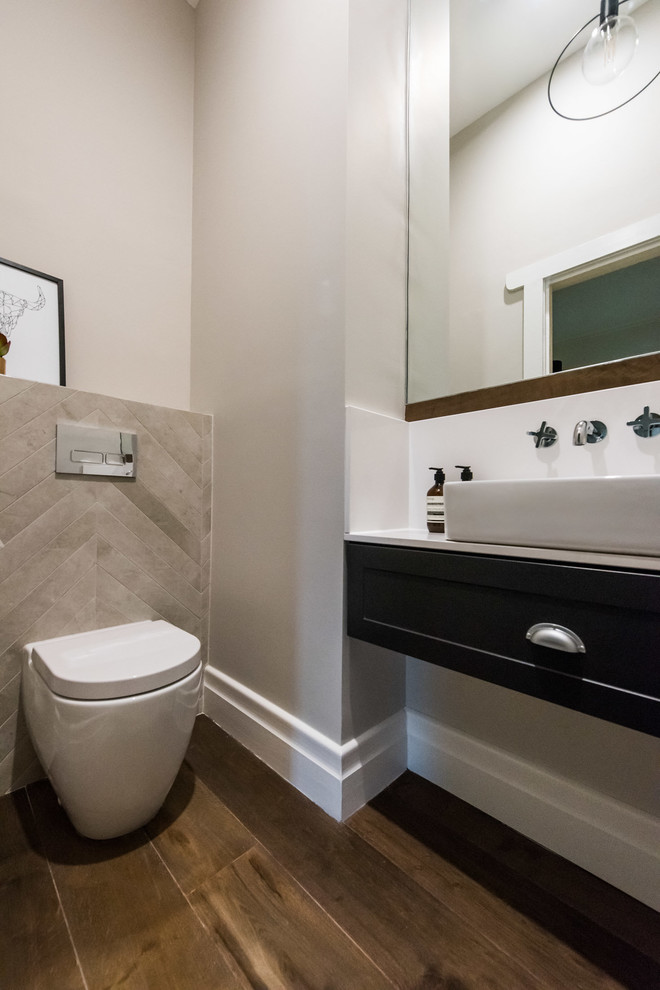 Kleine Moderne Gästetoilette mit Kassettenfronten, blauen Schränken, Toilette mit Aufsatzspülkasten, grauen Fliesen, Porzellanfliesen, grauer Wandfarbe, braunem Holzboden, Aufsatzwaschbecken, Quarzwerkstein-Waschtisch und braunem Boden in Melbourne