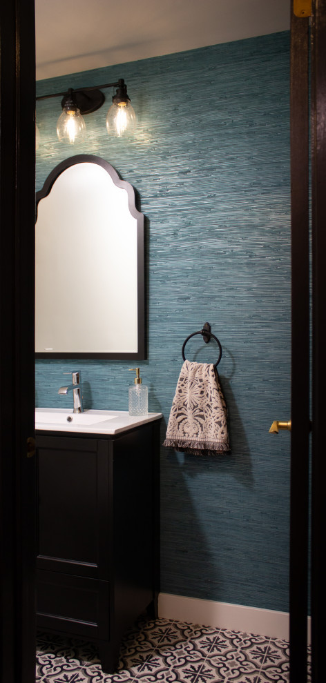 Modelo de aseo de pie actual pequeño con puertas de armario negras, paredes azules, suelo de azulejos de cemento, encimeras blancas y papel pintado