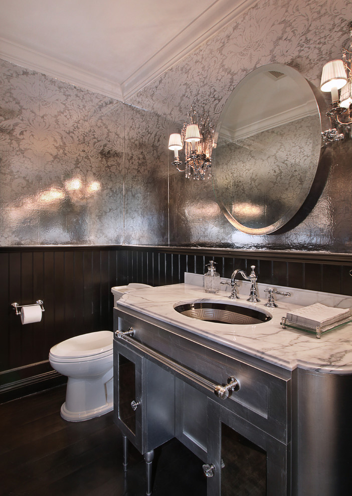Immagine di un bagno di servizio tradizionale di medie dimensioni con ante con riquadro incassato, ante grigie, top in marmo, WC monopezzo e parquet scuro