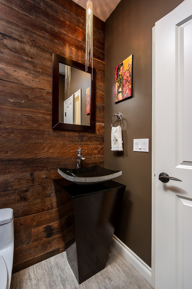 Immagine di un piccolo bagno di servizio tradizionale con WC monopezzo, piastrelle grigie, pareti marroni, pavimento in gres porcellanato e lavabo a colonna