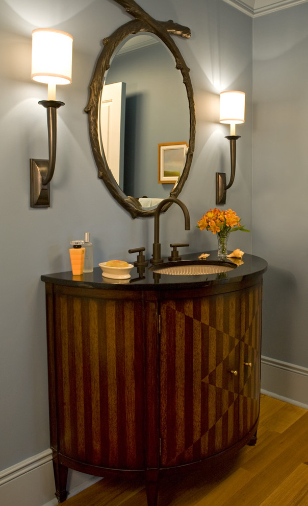 Idee per un bagno di servizio minimal con lavabo a bacinella, ante lisce e ante in legno bruno