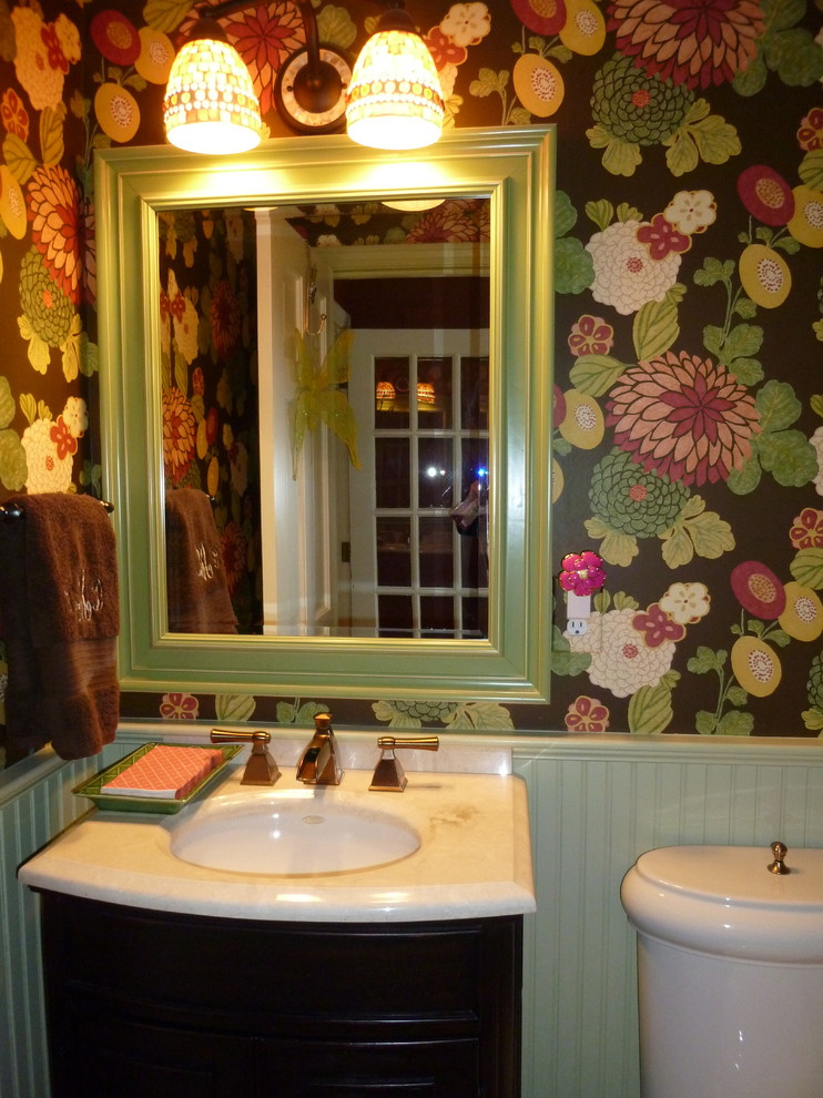 Exemple d'un petit WC et toilettes éclectique en bois foncé avec un lavabo encastré, un placard en trompe-l'oeil, un plan de toilette en marbre, un mur multicolore et un sol en bois brun.