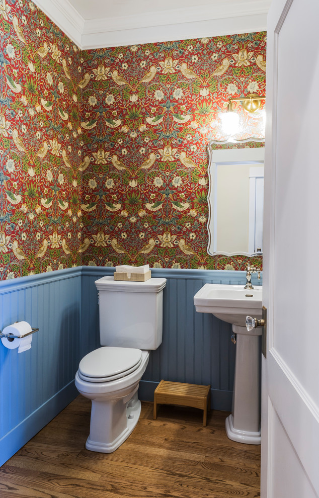 Ispirazione per un bagno di servizio country di medie dimensioni con WC a due pezzi, pareti blu, pavimento in legno massello medio, lavabo a colonna e pavimento marrone