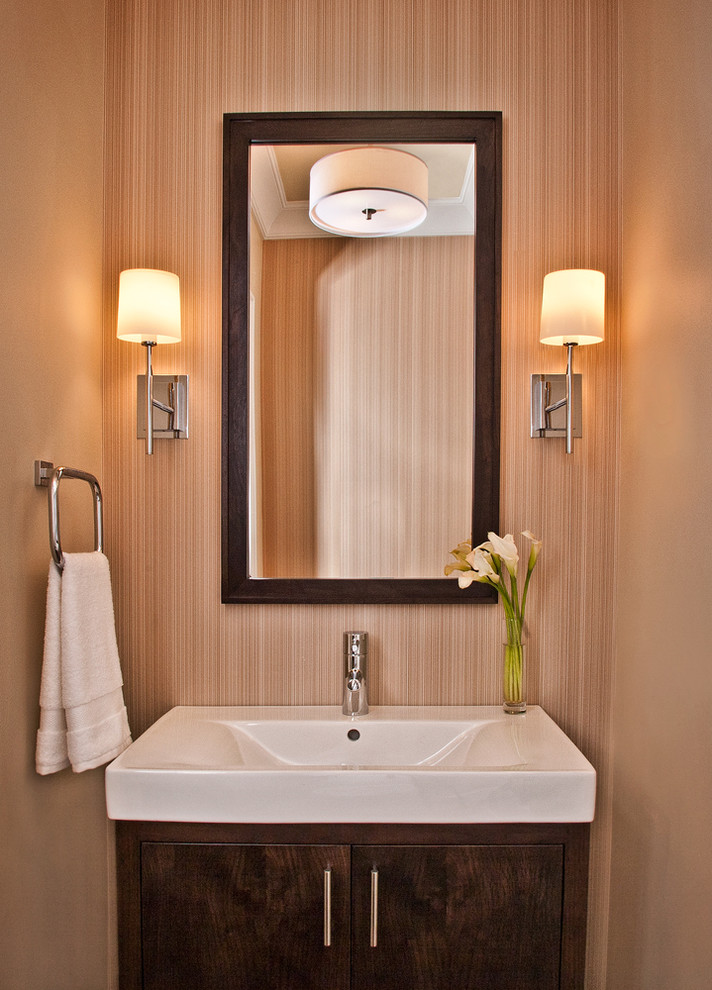Idee per un piccolo bagno di servizio con lavabo integrato, ante lisce, ante in legno bruno e pareti beige