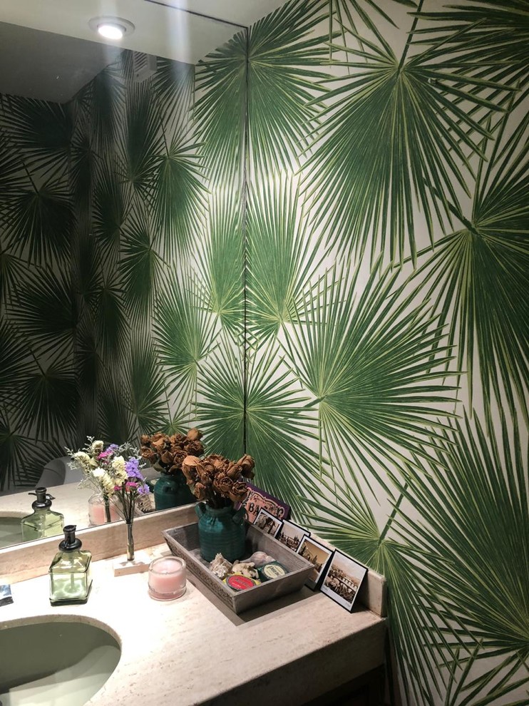 Example of a small island style powder room design in Miami with green walls