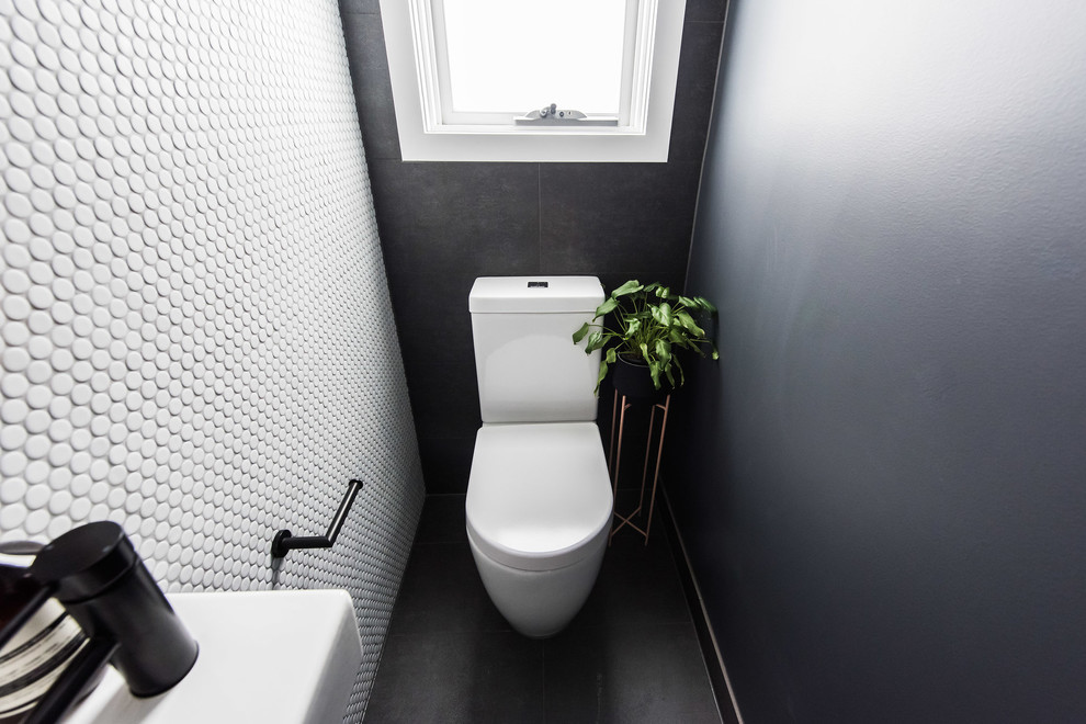 Свежая идея для дизайна: туалет в современном стиле с унитазом-моноблоком, черно-белой плиткой, плиткой мозаикой, полом из керамогранита, подвесной раковиной и черным полом - отличное фото интерьера