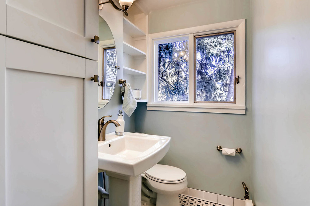 Inredning av ett klassiskt litet toalett, med skåp i shakerstil, vita skåp, en toalettstol med separat cisternkåpa, grå väggar, klinkergolv i keramik och ett piedestal handfat