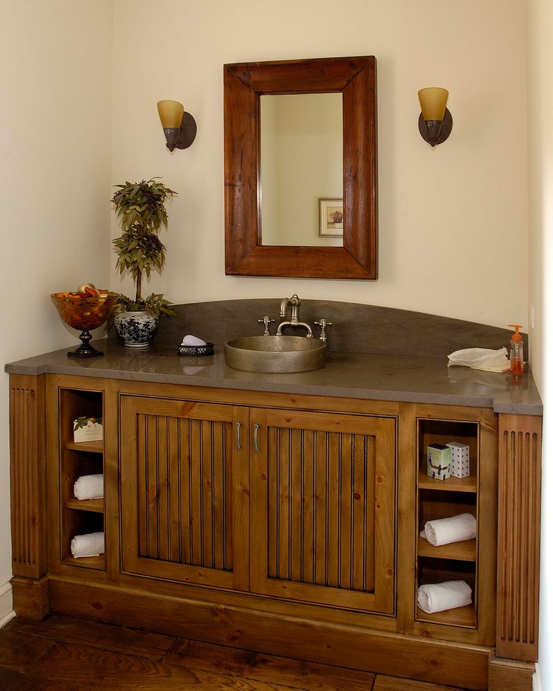 Esempio di un bagno di servizio tradizionale di medie dimensioni con consolle stile comò, ante in legno scuro, pareti beige, pavimento in legno massello medio, lavabo a bacinella, top in granito e pavimento marrone