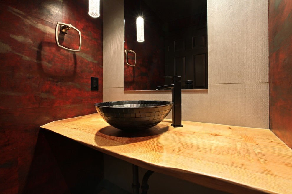 Idee per un bagno di servizio bohémian con pareti rosse, lavabo a bacinella e top in legno