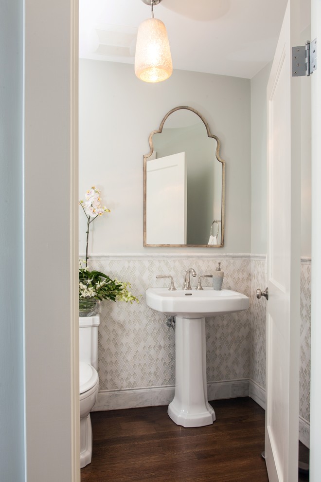Inspiration för små klassiska toaletter, med ett piedestal handfat, en toalettstol med separat cisternkåpa, vit kakel, mosaik, grå väggar och mellanmörkt trägolv