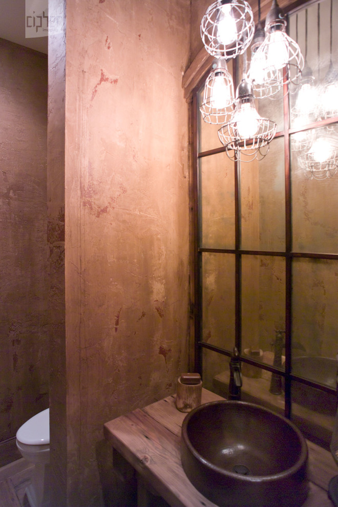 Foto di un bagno di servizio stile rurale di medie dimensioni con nessun'anta, ante in legno chiaro, WC a due pezzi, piastrelle a specchio, pareti beige, lavabo a bacinella e top in legno