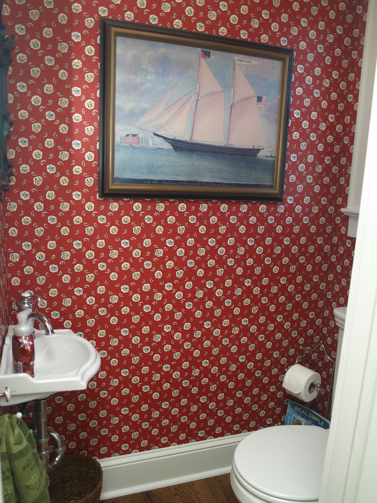 Inspiration för ett litet maritimt toalett, med röda väggar, mellanmörkt trägolv, ett konsol handfat och brunt golv