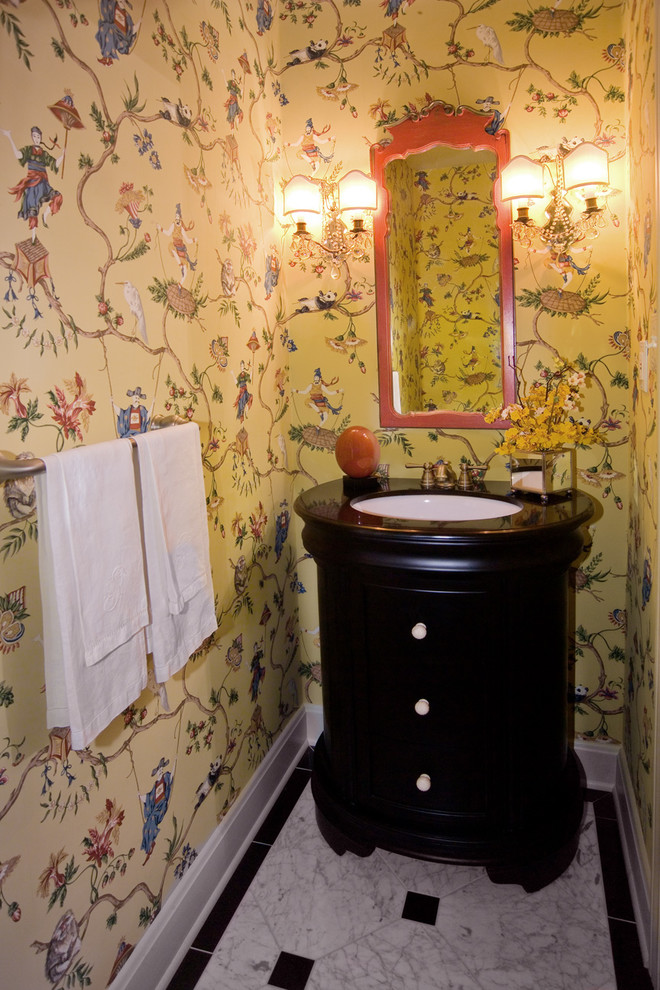 Aménagement d'un petit WC et toilettes asiatique avec un lavabo posé, des portes de placard noires, un mur jaune et un sol en marbre.