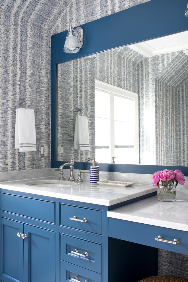 Klassische Gästetoilette mit Kassettenfronten, blauen Schränken, bunten Wänden, Unterbauwaschbecken und weißer Waschtischplatte in New York