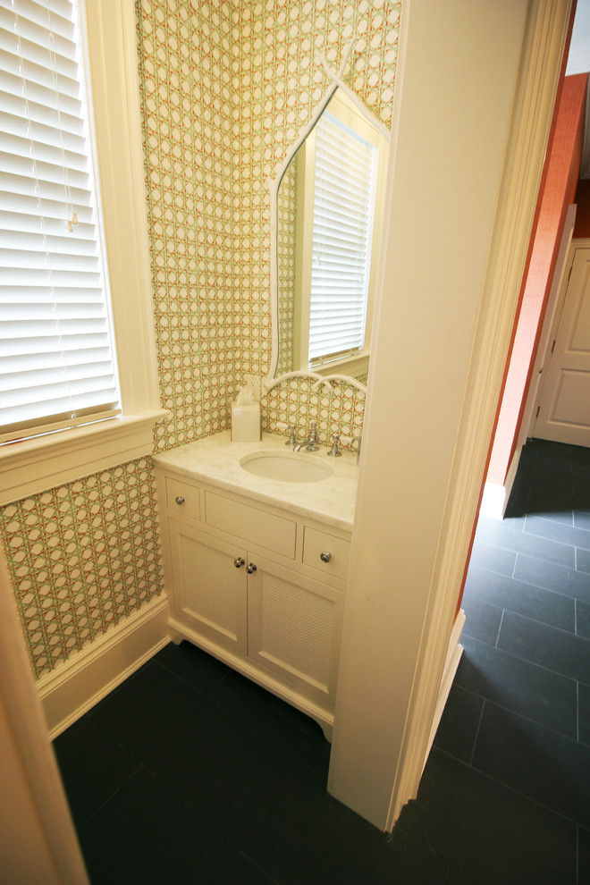 Inspiration pour un petit WC et toilettes traditionnel avec un placard avec porte à panneau encastré, des portes de placard blanches, WC séparés, un sol en carrelage de céramique, un plan de toilette en marbre, un mur multicolore et un lavabo encastré.