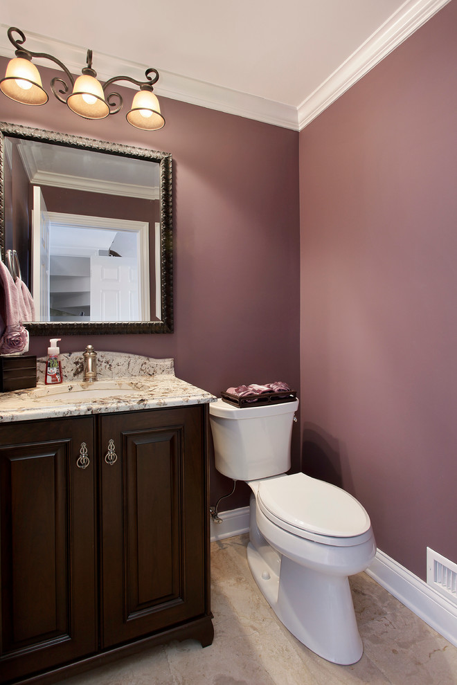 Small transitional beige tile powder room photo in Chicago with an undermount sink, raised-panel cabinets, dark wood cabinets, granite countertops, a two-piece toilet, pink walls and beige countertops