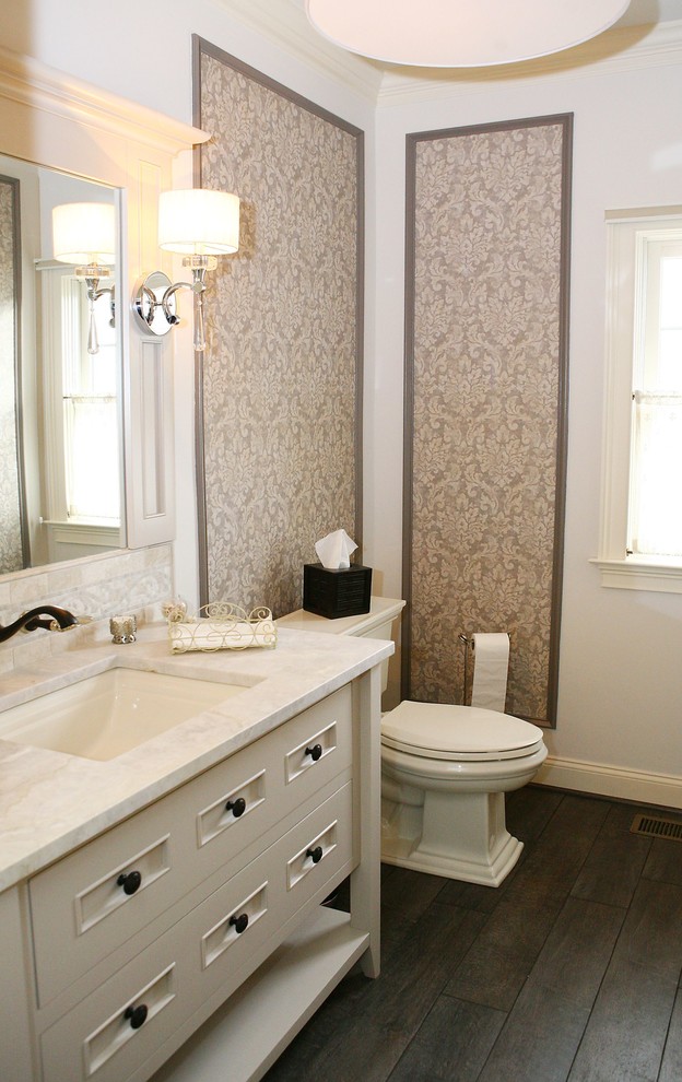 Mid-sized transitional plywood floor powder room photo in Philadelphia with furniture-like cabinets, white cabinets, a two-piece toilet, beige walls, an undermount sink, marble countertops and white countertops