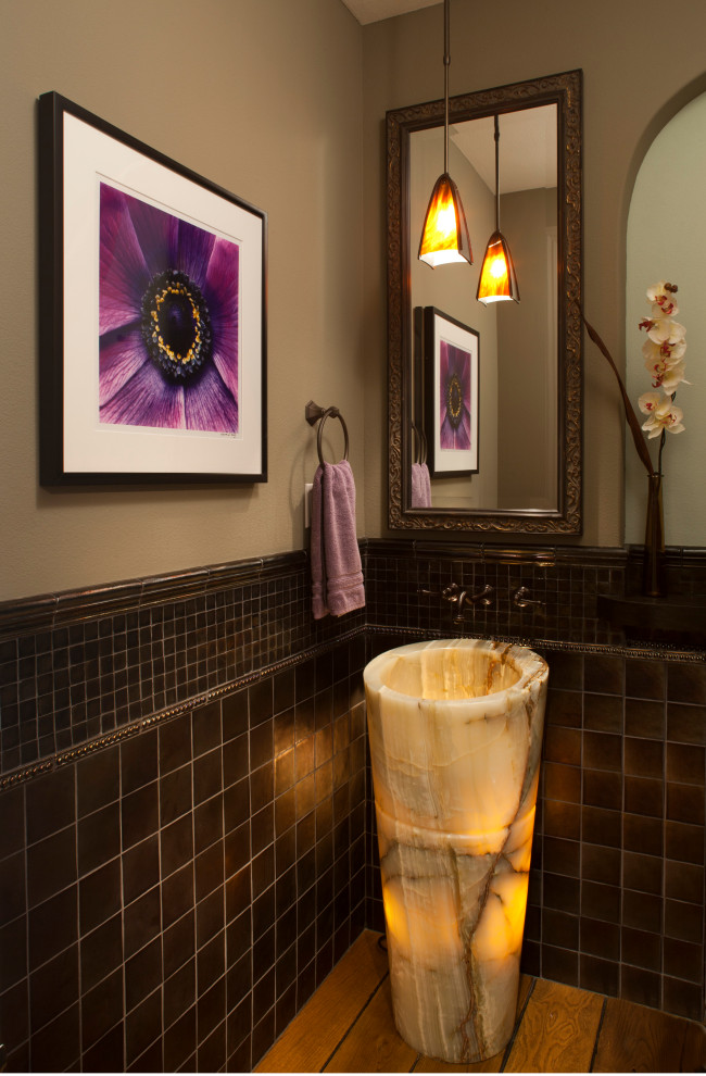 Inspiration för ett mellanstort medelhavsstil toalett, med svart kakel, glaskakel, mellanmörkt trägolv, ett piedestal handfat, marmorbänkskiva och brunt golv
