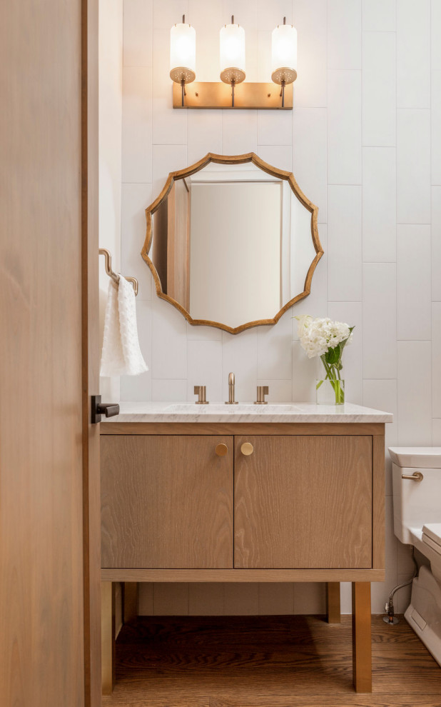 Powder room - mid-sized transitional white tile dark wood floor and brown floor powder room idea in Denver with flat-panel cabinets, white walls, marble countertops, white countertops, medium tone wood cabinets, a one-piece toilet, an undermount sink and a freestanding vanity