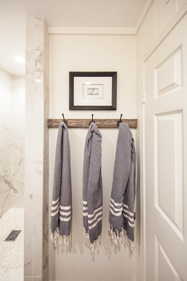 This is an example of a small beach style cloakroom in Orange County with a one-piece toilet, white tiles, porcelain tiles, white walls, dark hardwood flooring, a submerged sink, engineered stone worktops and brown floors.