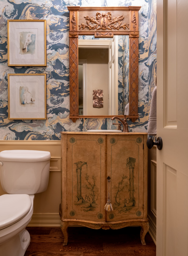 Aménagement d'un WC et toilettes classique en bois brun avec un placard en trompe-l'oeil, un mur multicolore, parquet foncé, un lavabo posé, un plan de toilette en bois et un sol marron.