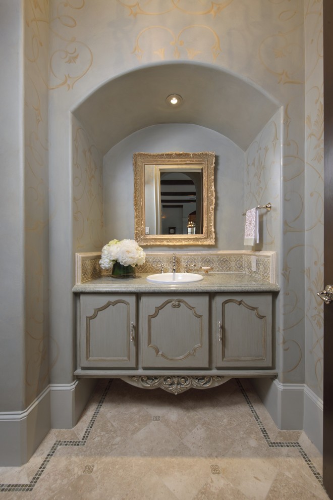 Tuscan beige tile powder room photo in Houston with a drop-in sink, recessed-panel cabinets and gray cabinets