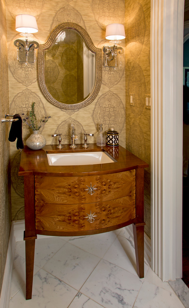 Cette image montre un petit WC et toilettes traditionnel en bois brun avec un lavabo encastré, un placard en trompe-l'oeil, un plan de toilette en bois, un mur beige, un sol en marbre et un plan de toilette marron.