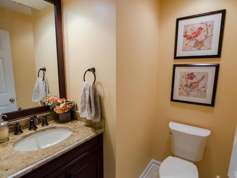 Small elegant powder room photo in DC Metro with dark wood cabinets, granite countertops and an undermount sink