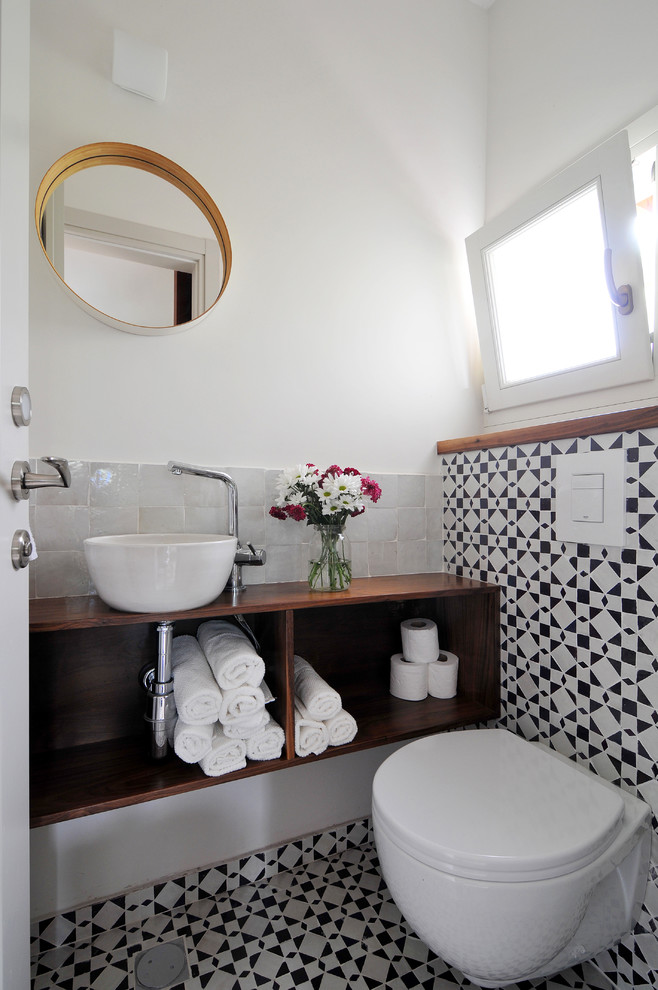 Идея дизайна: туалет в современном стиле с инсталляцией, черно-белой плиткой, белыми стенами и настольной раковиной