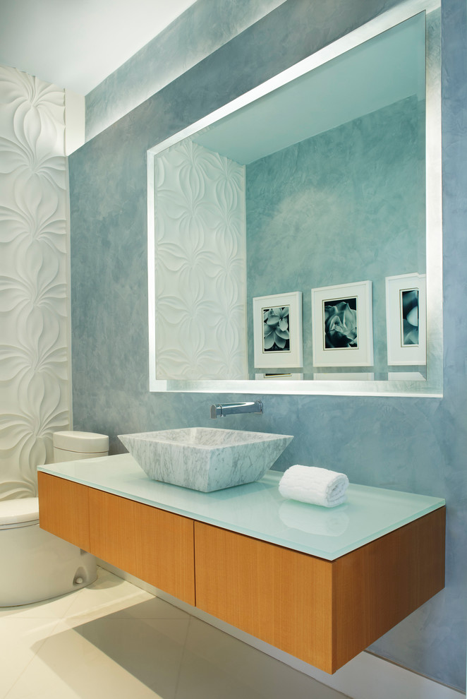 Idee per un bagno di servizio minimal con lavabo a bacinella, top in vetro e top turchese