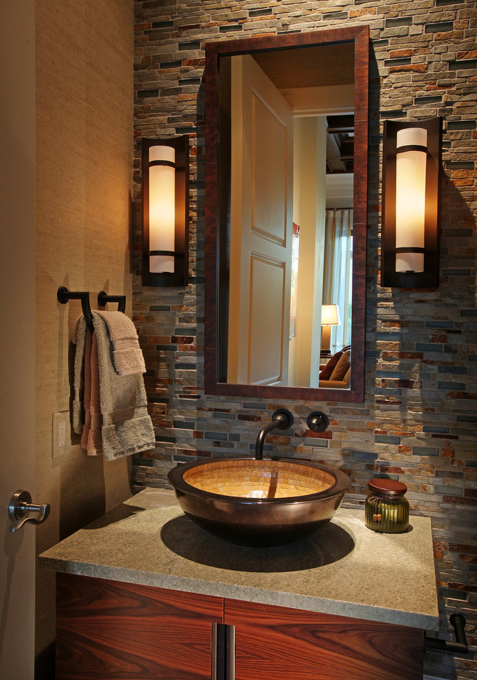Cette image montre un WC et toilettes traditionnel en bois foncé avec une vasque, un placard à porte plane, un carrelage multicolore, du carrelage en ardoise et un plan de toilette gris.