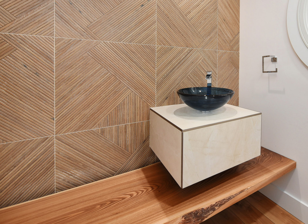 Moderne Gästetoilette mit braunen Fliesen, weißer Wandfarbe, braunem Holzboden, Aufsatzwaschbecken, braunem Boden und beiger Waschtischplatte in Sonstige