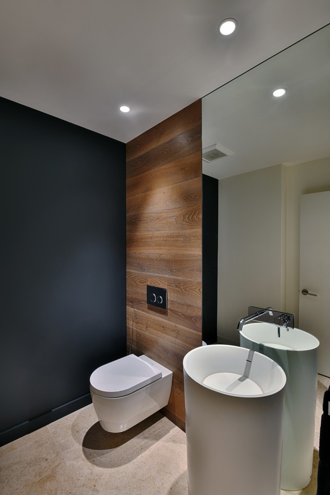 Design ideas for a contemporary cloakroom in San Diego with a wall mounted toilet, black walls, a pedestal sink and beige floors.