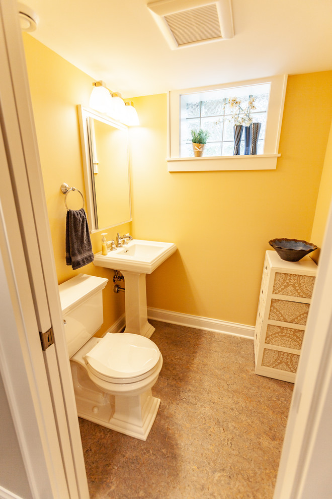 На фото: туалет в стиле неоклассика (современная классика) с унитазом-моноблоком, желтыми стенами, полом из линолеума, раковиной с пьедесталом и бежевым полом