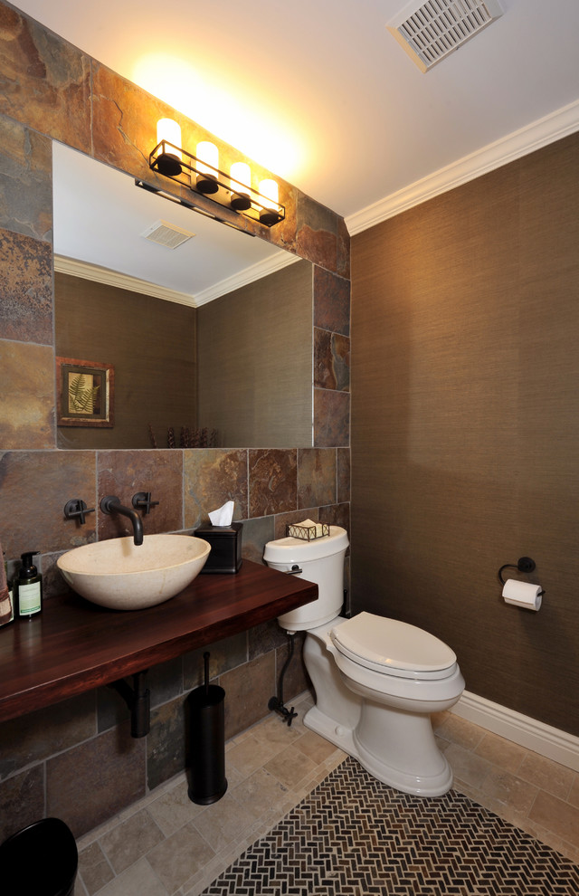 Exempel på ett litet klassiskt toalett, med en toalettstol med separat cisternkåpa, flerfärgad kakel, bruna väggar, travertin golv, ett fristående handfat, träbänkskiva och skifferkakel