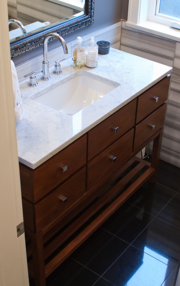 This is an example of a medium sized modern cloakroom in Vancouver with a submerged sink, flat-panel cabinets, medium wood cabinets, grey walls, marble worktops, black floors and white worktops.