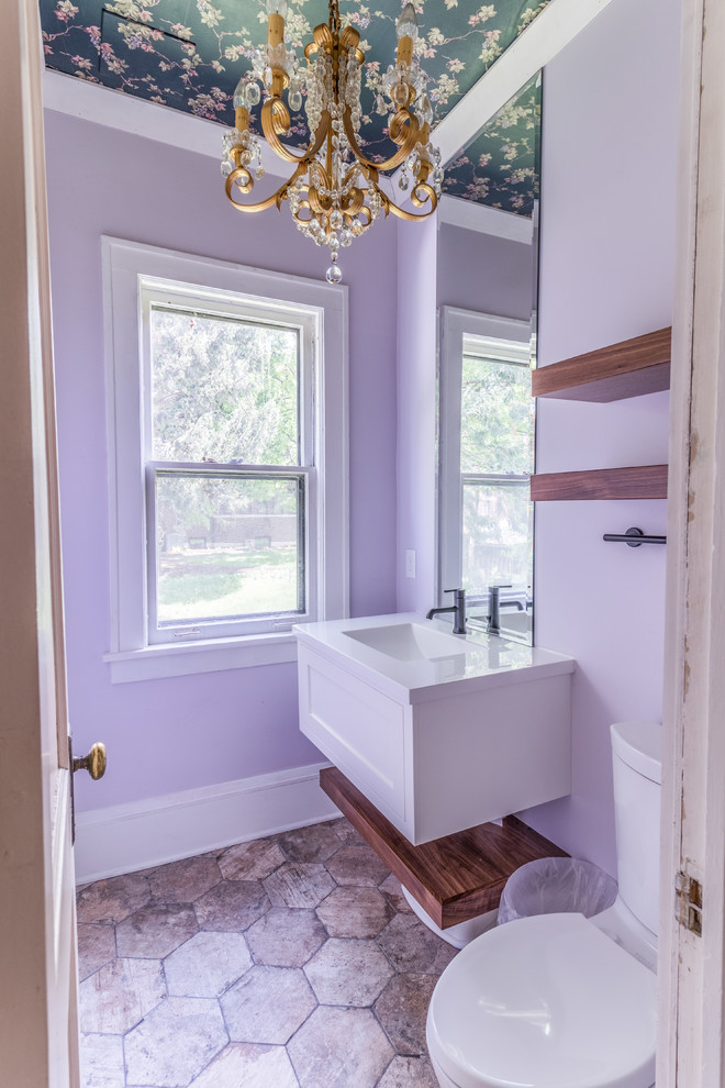 This is an example of a medium sized traditional cloakroom in Minneapolis with recessed-panel cabinets, white cabinets, a one-piece toilet, purple walls, ceramic flooring, an integrated sink, marble worktops, beige floors and white worktops.