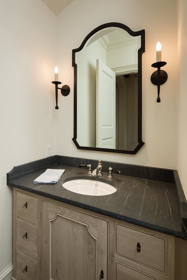 Réalisation d'un WC et toilettes tradition en bois clair de taille moyenne avec un placard avec porte à panneau encastré, un mur blanc, un lavabo encastré, un plan de toilette en granite et un plan de toilette noir.