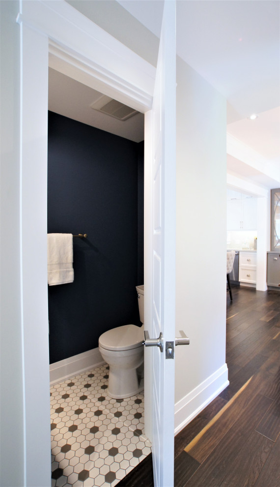 Aménagement d'un petit WC et toilettes classique avec un placard à porte shaker, des portes de placard blanches, WC séparés, un mur bleu, un sol en carrelage de terre cuite, un lavabo intégré, un plan de toilette en surface solide, un sol multicolore et un plan de toilette blanc.