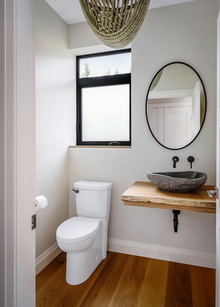 Inspiration pour un WC et toilettes design avec WC à poser, un mur gris, un sol en bois brun, une vasque, un plan de toilette en bois, un sol marron et un plan de toilette marron.